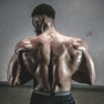 A shirtless man displaying his muscular back, showcasing strength and fitness.